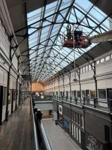 Boom lift performing electrical work below an atrium skylight