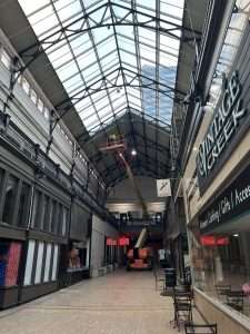 Boom lift reaching a glass atrium ceiling for electrical installation