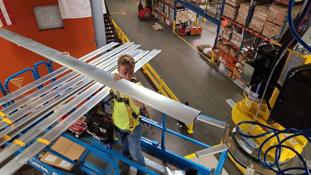 Electrician attaching HVLS fan blades in a distribution warehouse