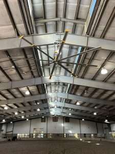 HVLS fan installed on the steel ceiling of an indoor arena
