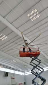 HVLS fan installation from a scissor lift inside an aircraft hangar
