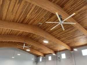 Large ceiling fans installed under an arched timber ceiling