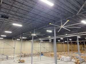 Multiple HVLS ceiling fans installed across a large warehouse