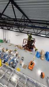 Overhead electrical installation from a lift above a distribution center floor