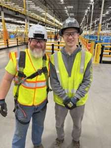 RISE Industrial Solutions electricians in hard hats and safety vests on a job site